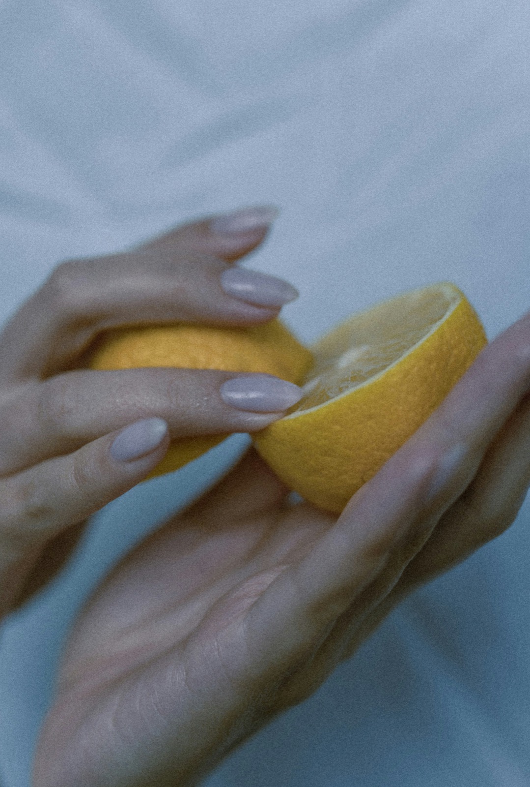 レモンを両手で持つ女性の手元