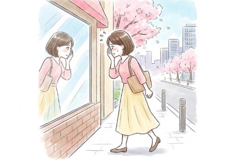 鏡越しに映った自分を見る女性