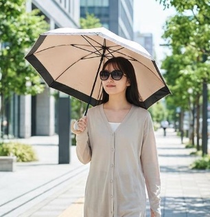 日傘とサングラスで紫外線対策をしている女性