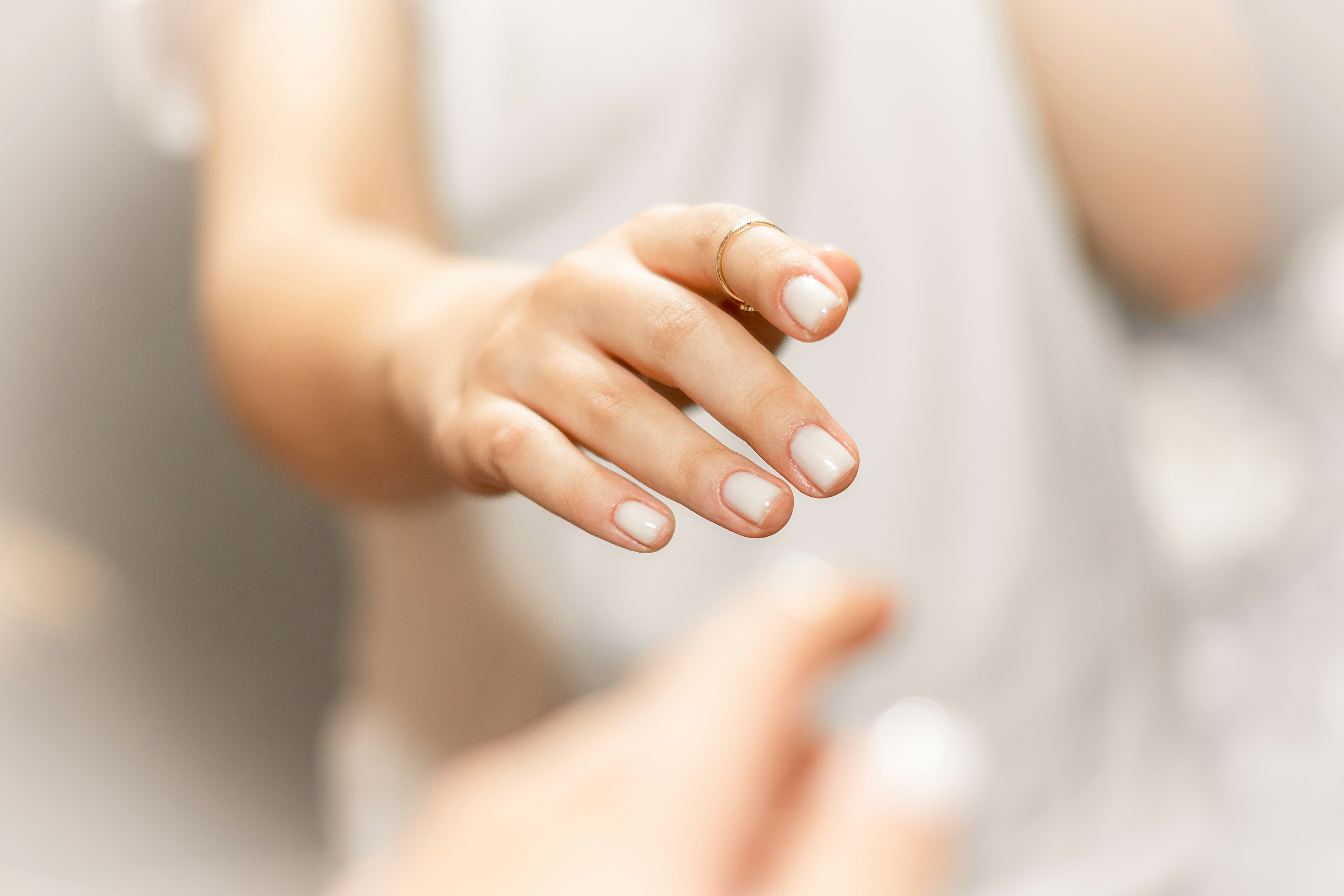 手を前に差し出した女性の腕と指先