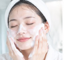 泡を顔にのせて洗っている女性