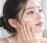 頬に美容液をなじませる女性