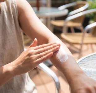 日焼け止めを塗っている女性